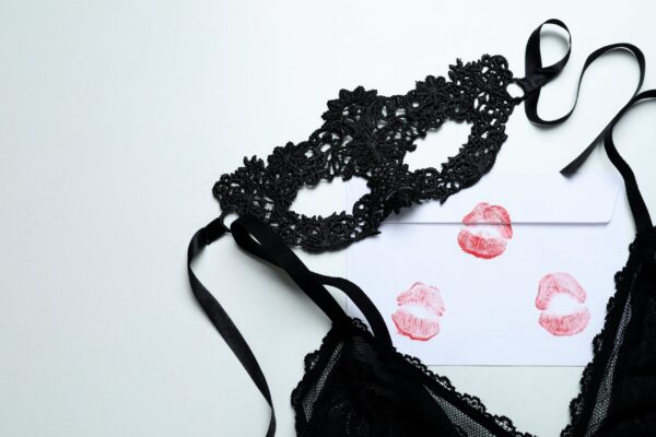 Costumi da donna sexy – donna in posa seducente con abito provocante rosso, ambientazione da boudoir elegante