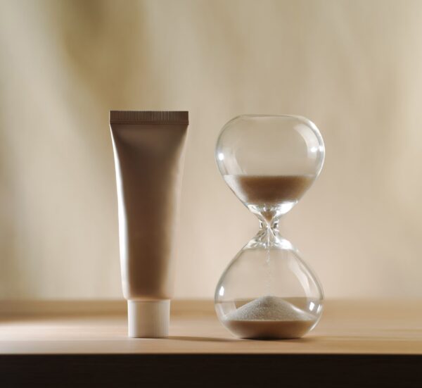 Ritardanti sessuali naturali: una clessidra e un tubo di crema evocano il controllo del tempo, la lentezza e il piacere prolungato